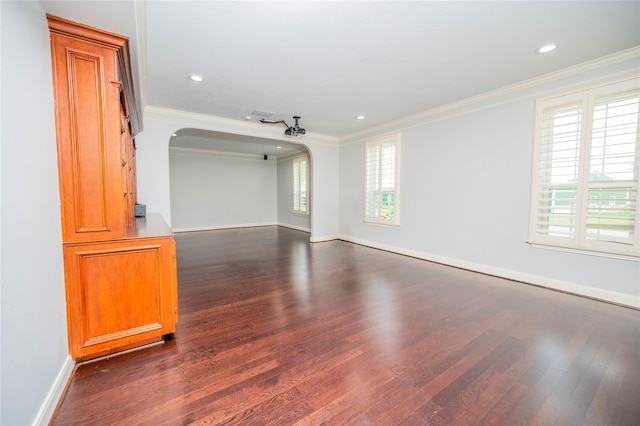 spare room with a wealth of natural light, dark hardwood / wood-style flooring, and crown molding