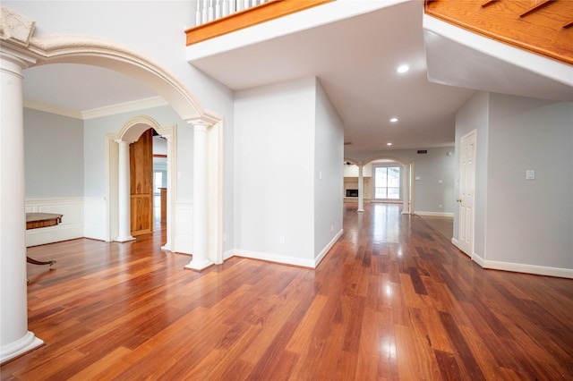 hall featuring hardwood / wood-style flooring, ornate columns, and crown molding