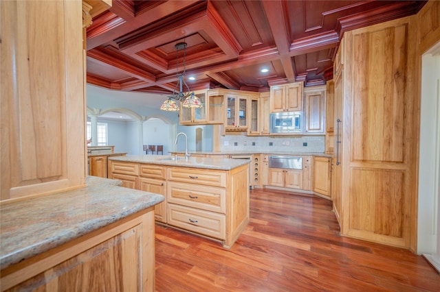 kitchen featuring coffered ceiling, sink, decorative light fixtures, light hardwood / wood-style floors, and stainless steel microwave