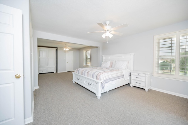 bedroom with multiple windows, ceiling fan, and light carpet