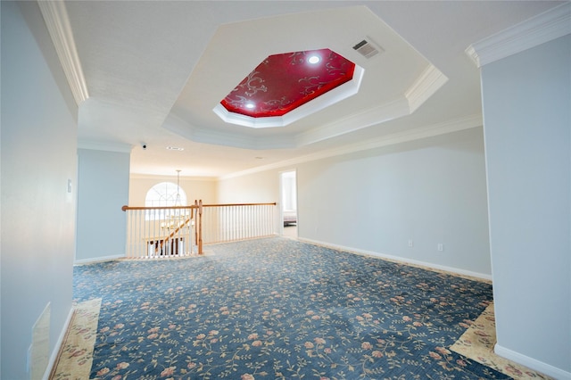 spare room with carpet flooring, a raised ceiling, and ornamental molding