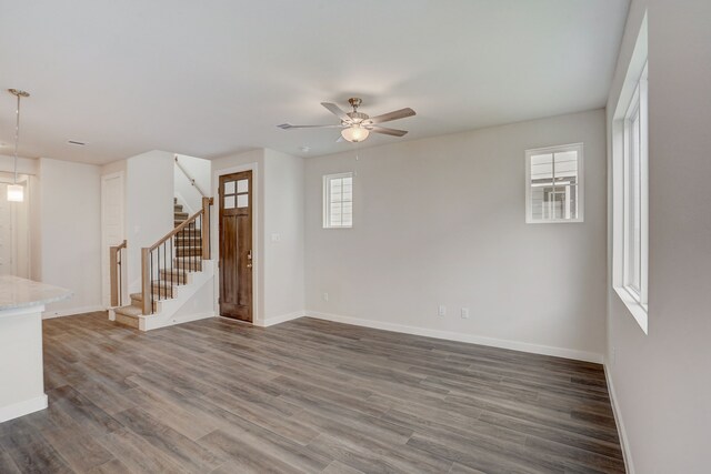 unfurnished room featuring dark hardwood / wood-style flooring, ceiling fan, and a healthy amount of sunlight