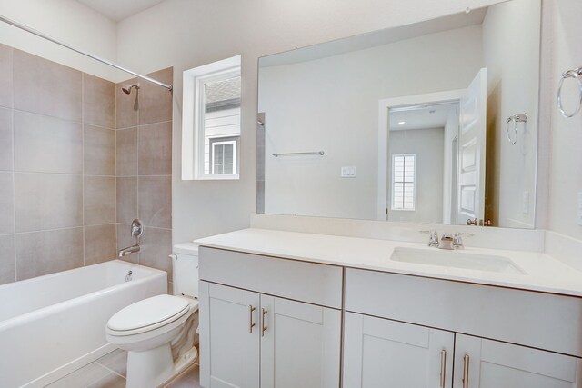 full bathroom with plenty of natural light, toilet, tiled shower / bath, and vanity