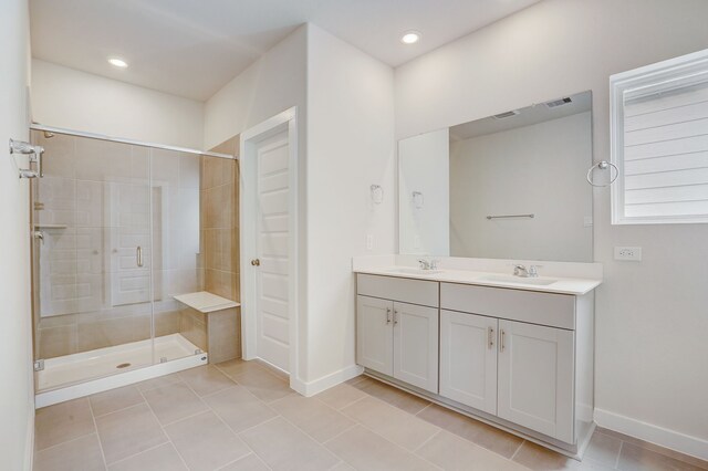 bathroom with tile patterned flooring, vanity, and walk in shower