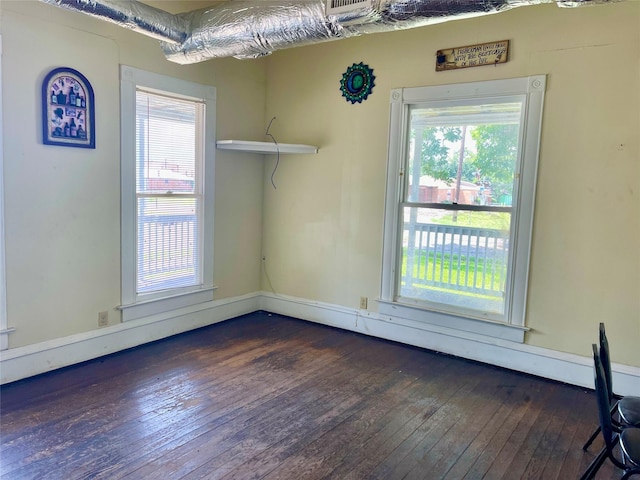 unfurnished room with dark hardwood / wood-style flooring and a healthy amount of sunlight