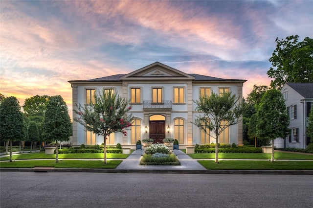 greek revival house featuring a yard and a balcony