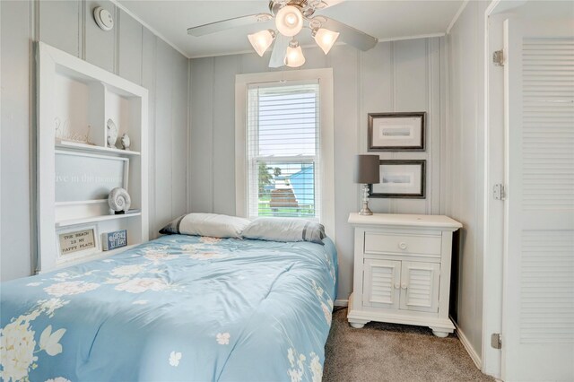 carpeted bedroom featuring crown molding and ceiling fan