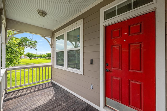 property entrance featuring covered porch and a yard