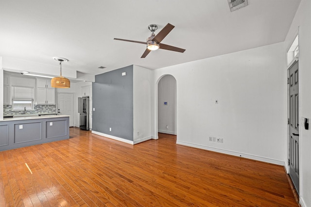 unfurnished living room featuring ceiling fan and light hardwood / wood-style floors