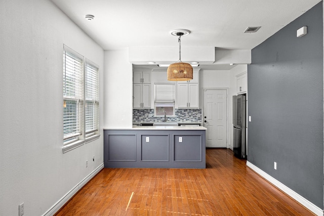 kitchen featuring decorative backsplash, gray cabinetry, pendant lighting, and sink