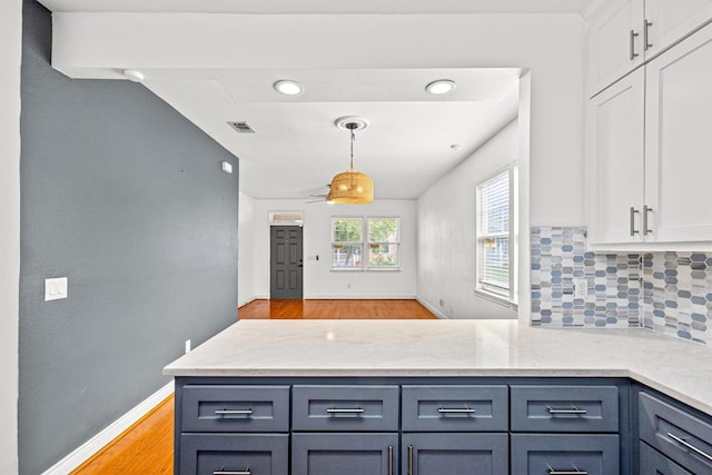 kitchen with white cabinets, decorative light fixtures, tasteful backsplash, ceiling fan, and light stone counters