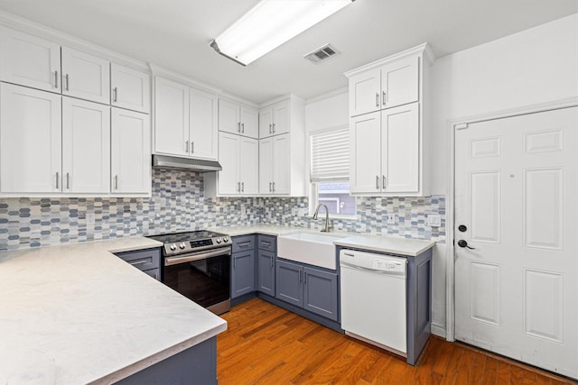 kitchen featuring white dishwasher, sink, white cabinetry, and stainless steel range with electric cooktop