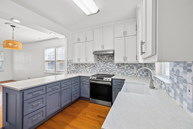 kitchen featuring white cabinets, wood-type flooring, sink, hanging light fixtures, and stainless steel range with electric stovetop