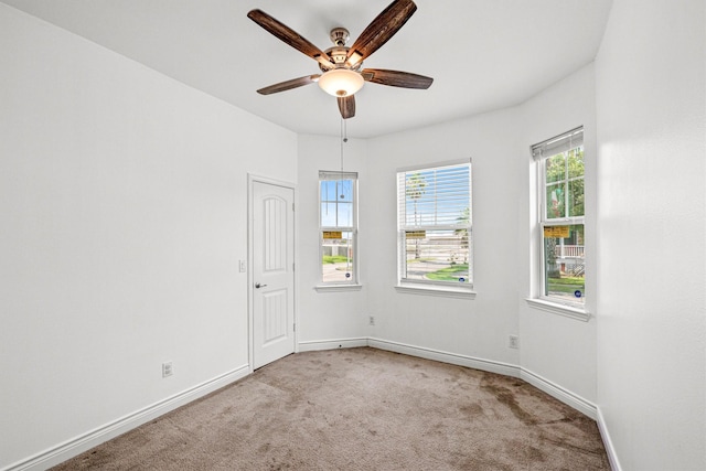 carpeted spare room featuring ceiling fan