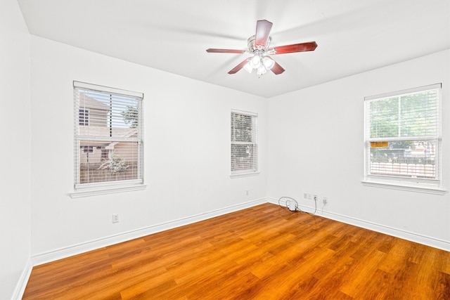 unfurnished room featuring ceiling fan, a healthy amount of sunlight, and hardwood / wood-style flooring