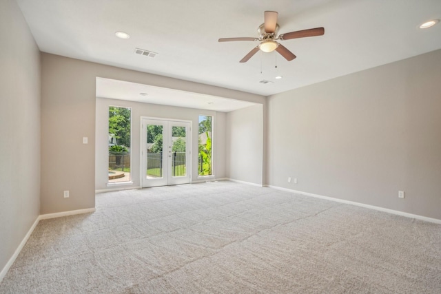 carpeted empty room featuring ceiling fan and french doors