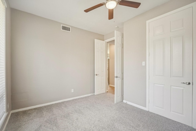 unfurnished bedroom with ceiling fan and light colored carpet