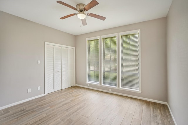 unfurnished bedroom featuring ceiling fan, a closet, and light hardwood / wood-style floors