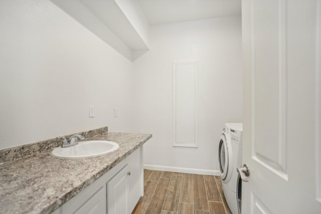 washroom with separate washer and dryer, sink, and dark hardwood / wood-style floors