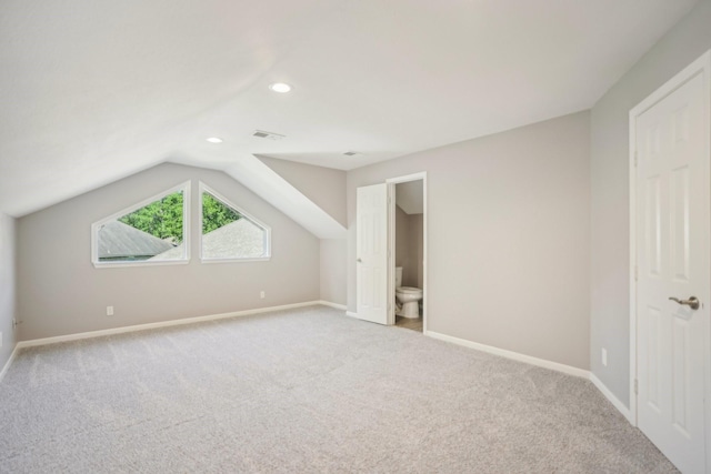 additional living space with light colored carpet and vaulted ceiling