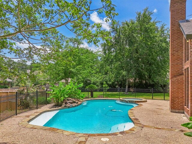 view of pool with an in ground hot tub