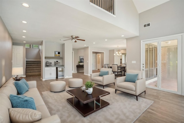 living room with a wealth of natural light, light hardwood / wood-style floors, and beverage cooler