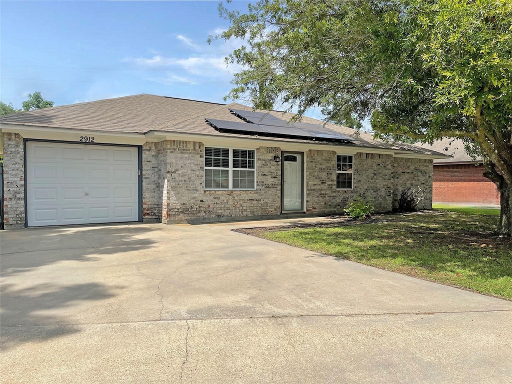 single story home with solar panels and a garage