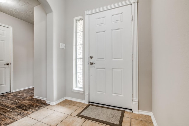 tiled entrance foyer featuring plenty of natural light and a textured ceiling