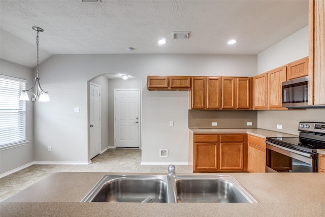 kitchen with sink, stainless steel appliances, an inviting chandelier, pendant lighting, and lofted ceiling