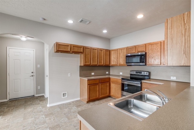 kitchen featuring a textured ceiling, sink, and appliances with stainless steel finishes