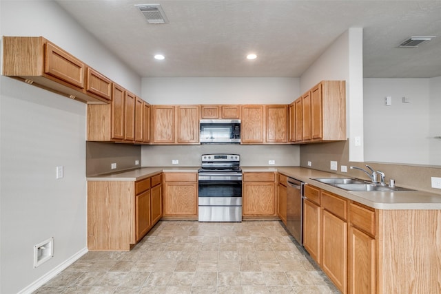 kitchen with sink, a textured ceiling, and appliances with stainless steel finishes