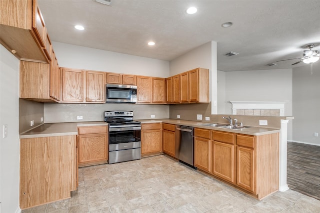 kitchen featuring a textured ceiling, ceiling fan, sink, and stainless steel appliances