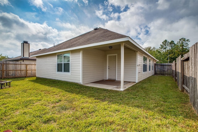 rear view of property with a lawn and a patio area