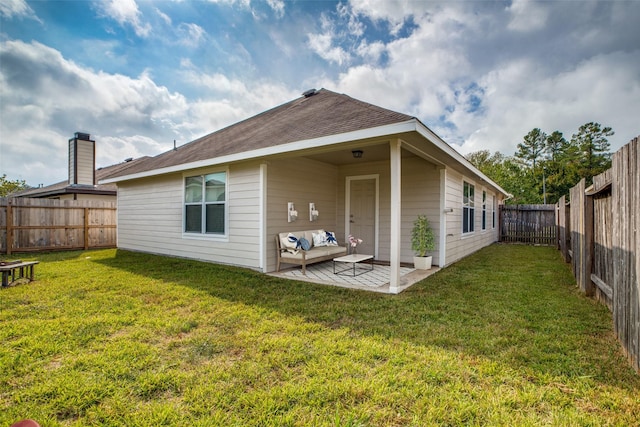 rear view of property with a patio area and a yard