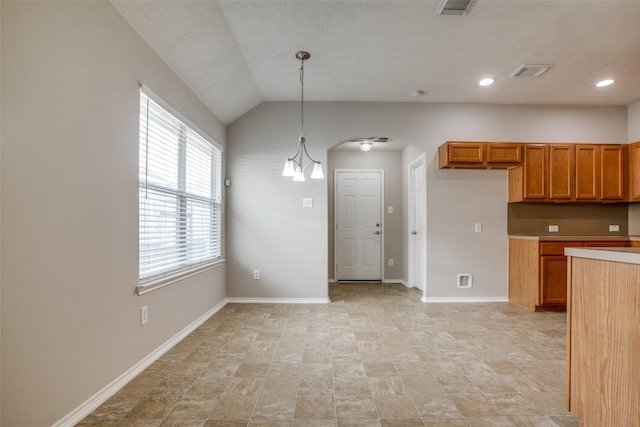 kitchen with vaulted ceiling, hanging light fixtures, and a notable chandelier