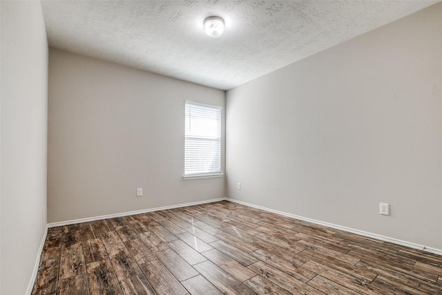 empty room with a textured ceiling and dark wood-type flooring