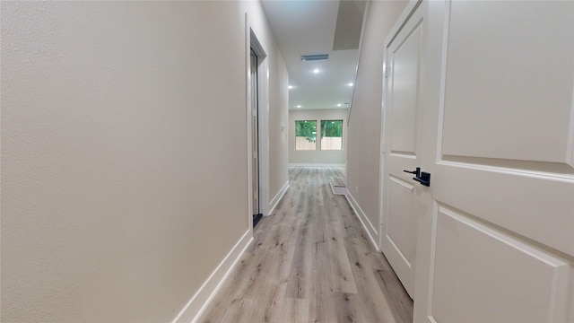 hallway with light hardwood / wood-style floors