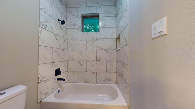 bathroom with toilet and tiled shower / bath combo