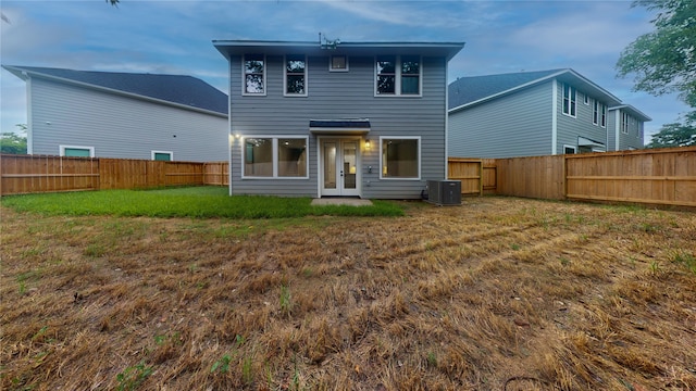 back of house with central AC and a yard