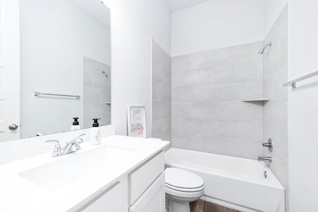 full bathroom featuring toilet, tiled shower / bath combo, and vanity