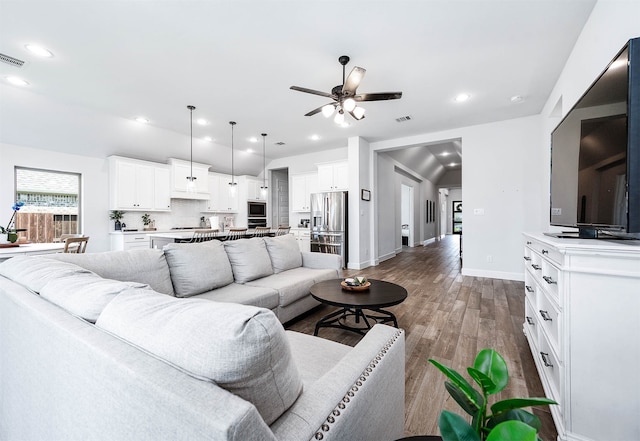 living room featuring ceiling fan and dark wood-type flooring