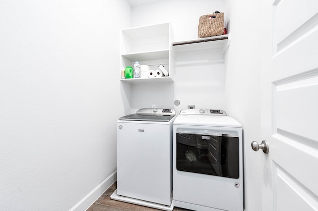 laundry room with dark hardwood / wood-style flooring and washing machine and clothes dryer