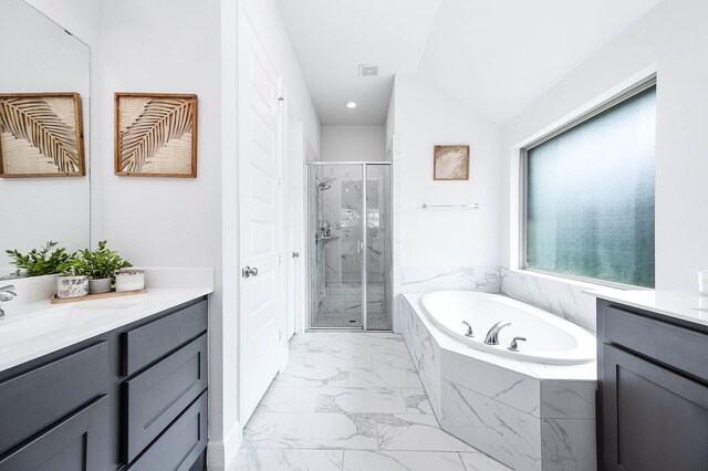 bathroom featuring vanity, lofted ceiling, and independent shower and bath