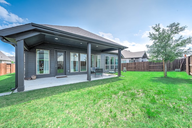 rear view of house with a lawn and a patio