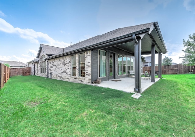 rear view of property with a yard and a patio