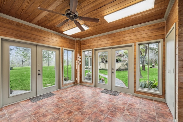 unfurnished sunroom featuring wood ceiling, ceiling fan, and french doors