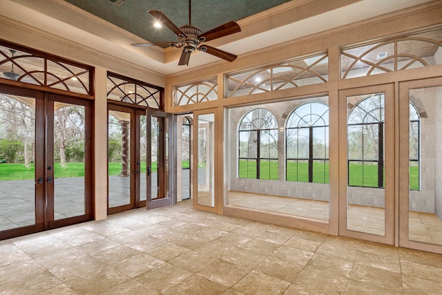 unfurnished sunroom featuring ceiling fan and french doors