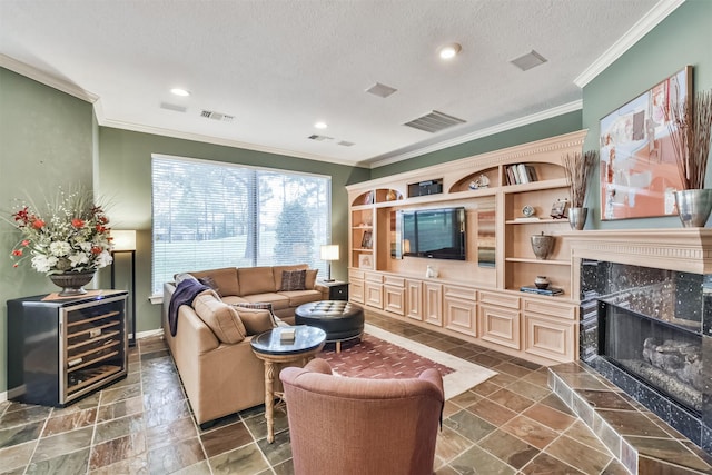 living room with a textured ceiling, ornamental molding, and a fireplace