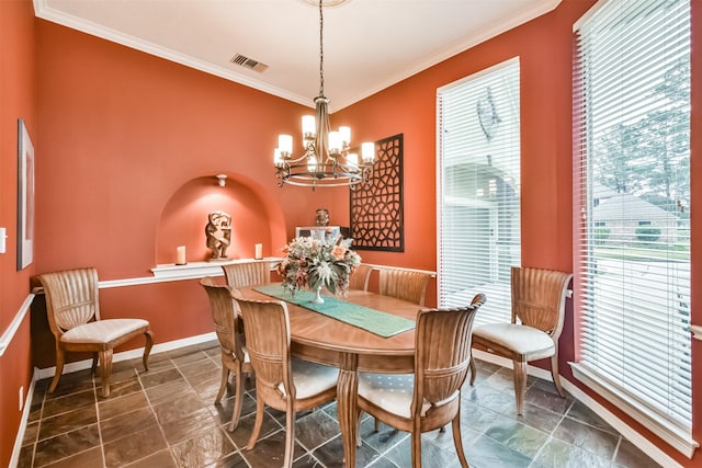 dining area featuring ornamental molding and an inviting chandelier