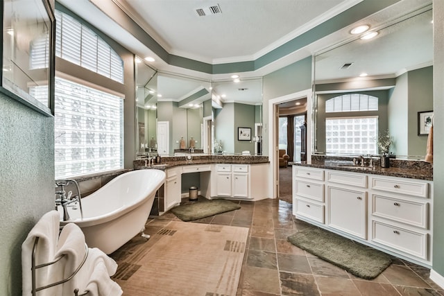 bathroom with a tub, plenty of natural light, vanity, and ornamental molding